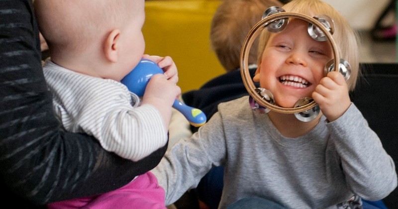 Lapsi hauskuuttaa vauvaa taburiinin kanssa
